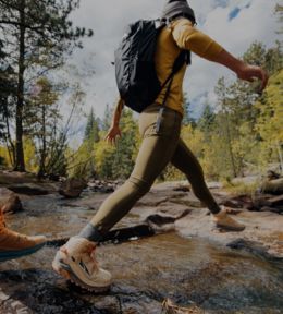 Image of a person crossing a stream with a backpack.