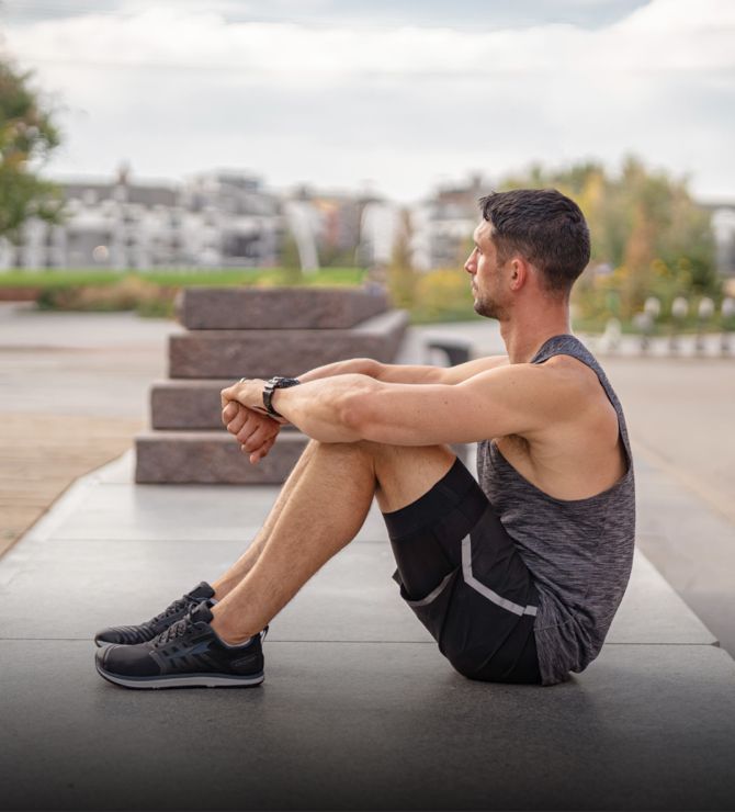 Image of a man sitting down in an outdoor exercise area.