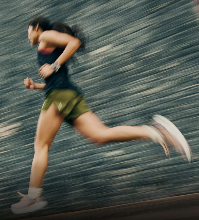Image of a woman running on a shady road.