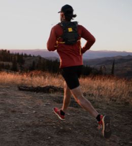 Image of a man trailrunning with a hydration vest.
